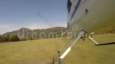 直升机降落在山区的直升机停机坪上。 小型轻型航空。 螺旋桨叶片的底部视图